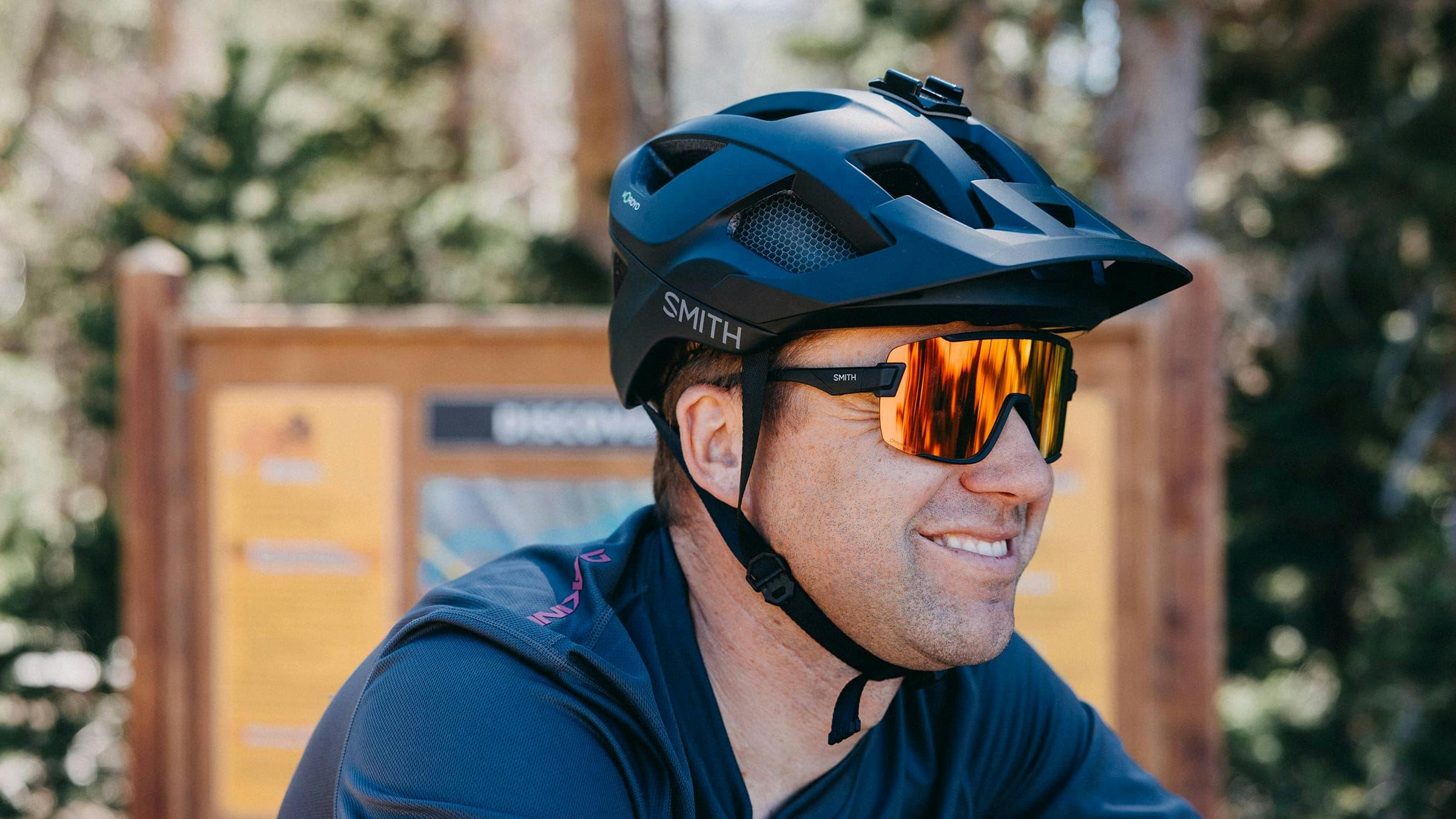 Close up of a man wearing a bike helmet.