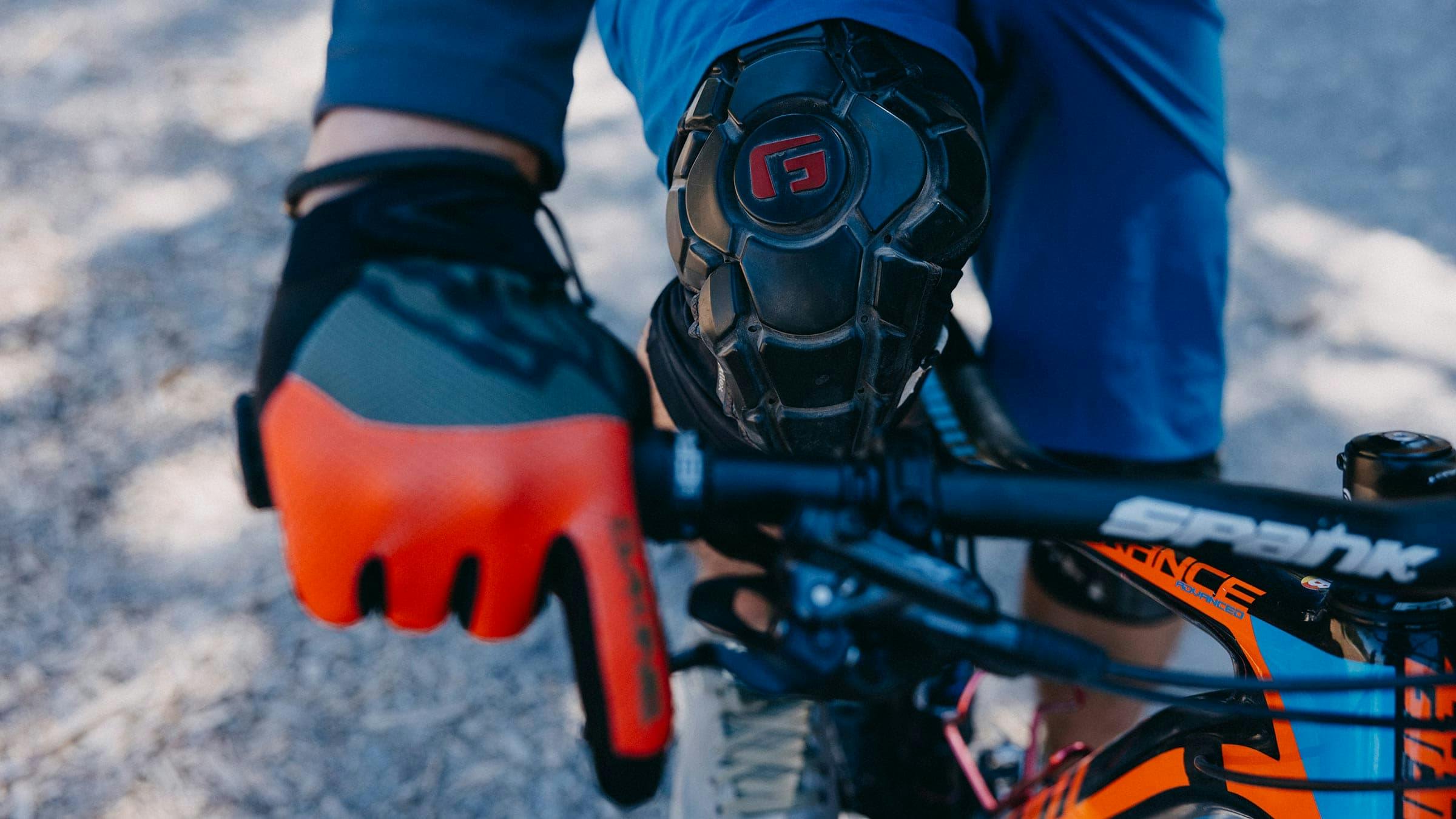 Close up of a mountain biker showing their glove and knee pad.