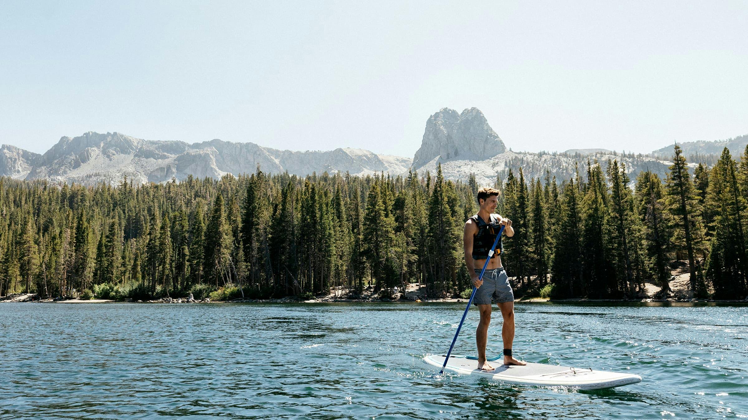 Man paddleboarding on Lake Mary in Mammoth Lakes.