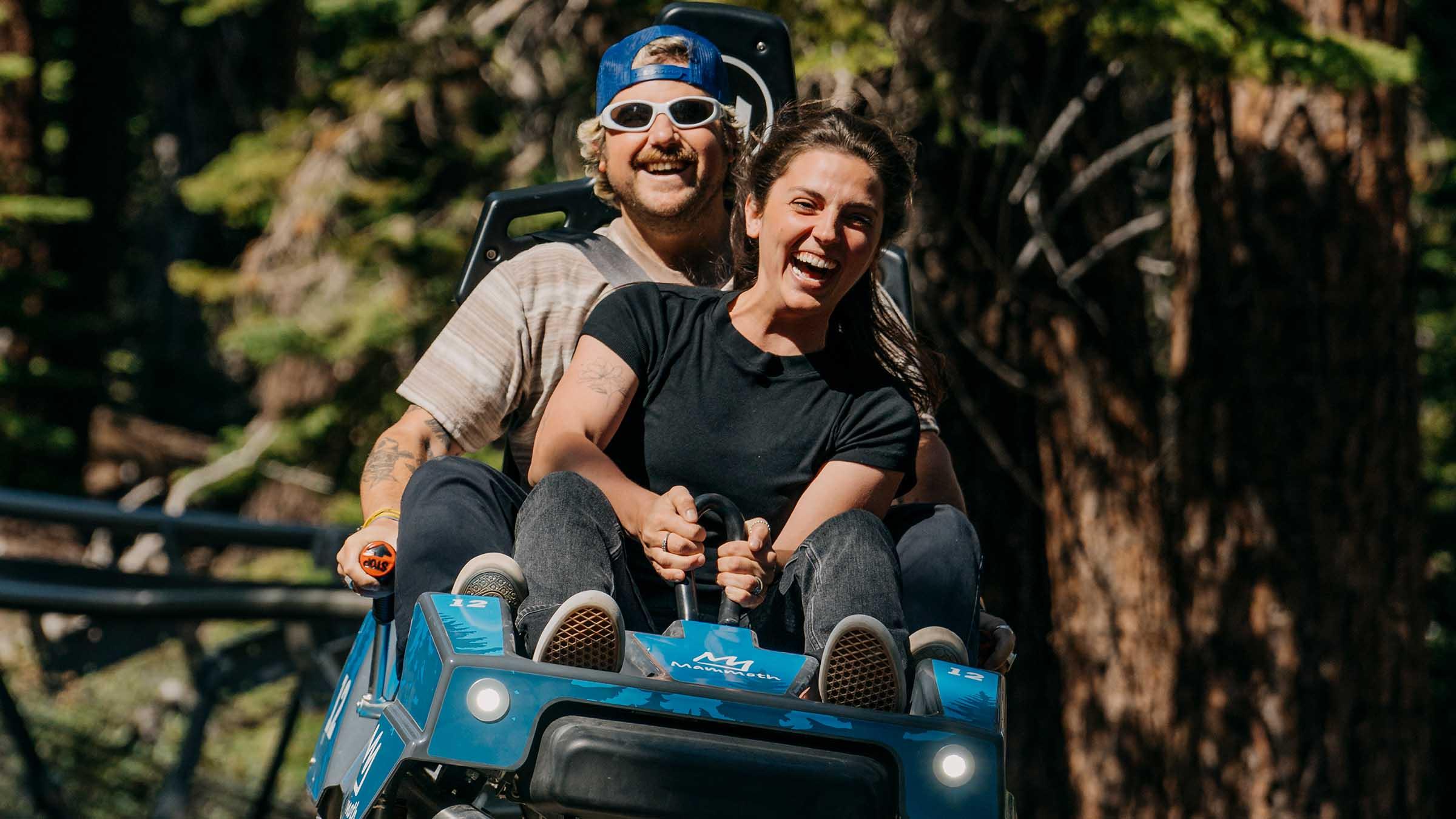 Two passengers riding the Mountain Coaster at Woolly's Adventure Summit