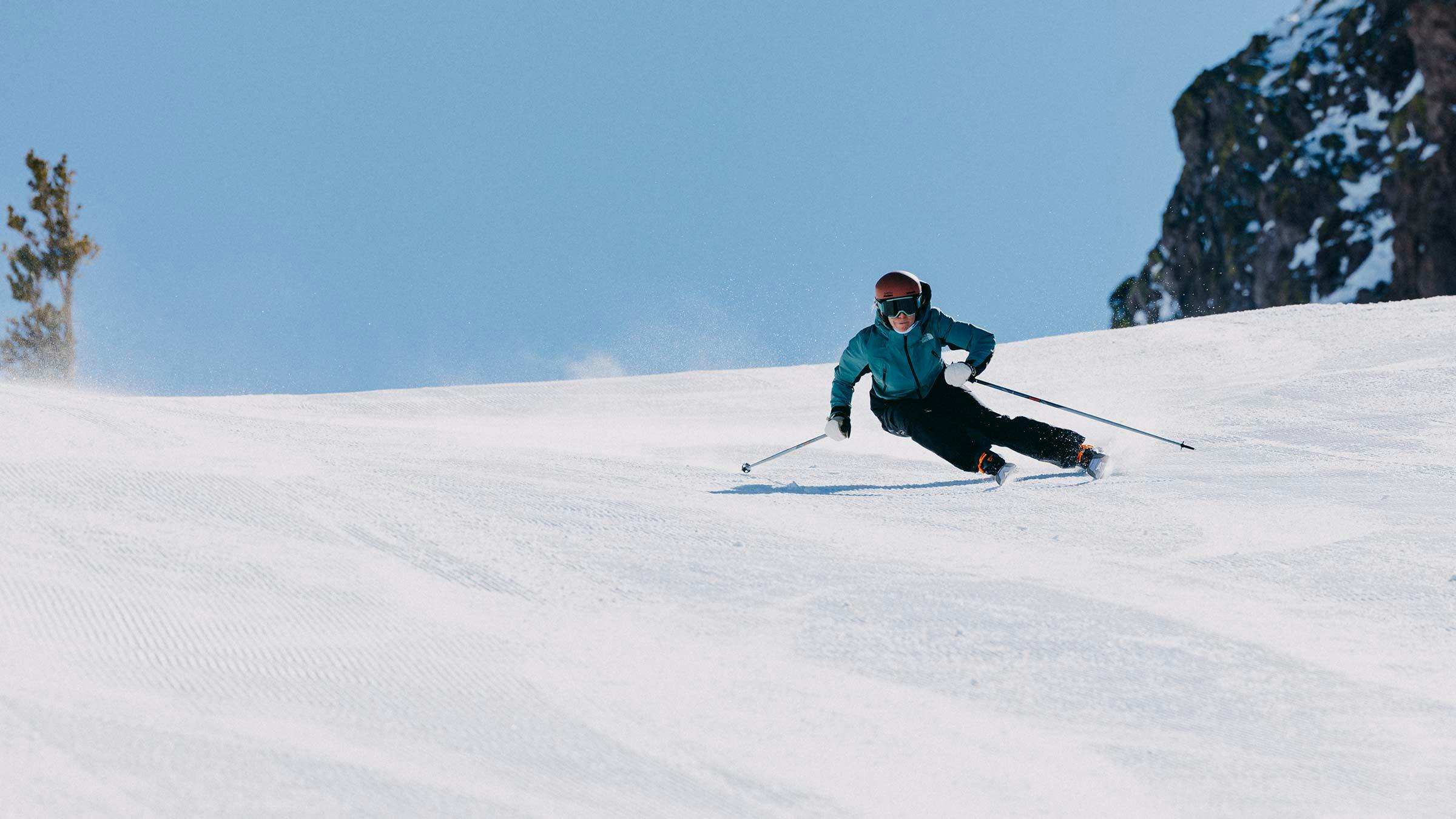 Woman skiing fast on a groomer run at Mammoth Mountain.