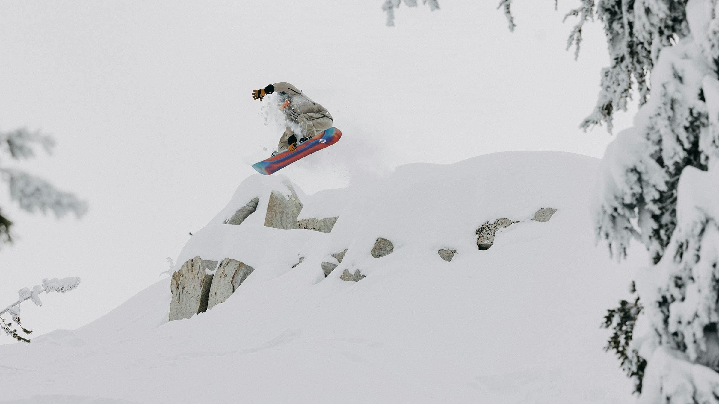 Snowboarder hitting a jump on a powder day at Mammoth Mountain.